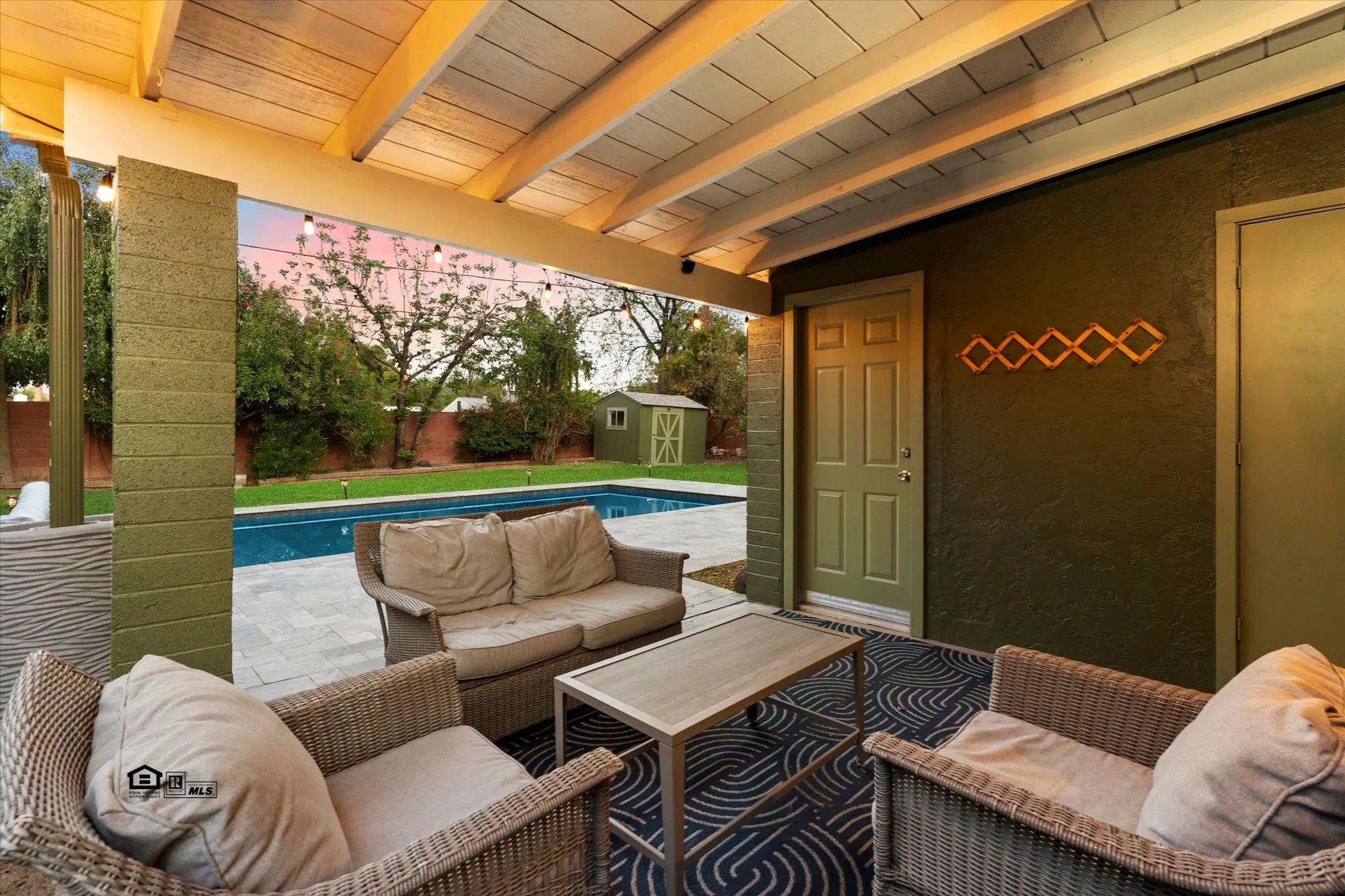 Staged covered patio beside a swimming pool